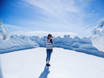 Man standing on snowcapped mountain against sky