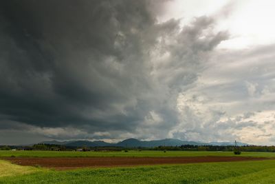 Scenic view of field against cloudy sky