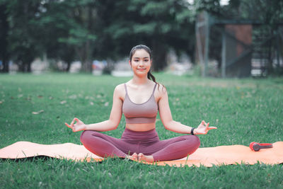 Portrait of smiling young woman sitting on field