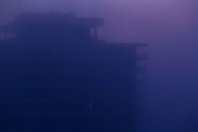 Silhouette buildings against sky at night