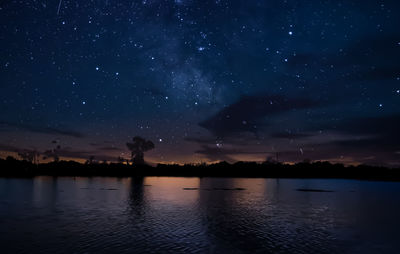 Scenic view of lake against sky at night