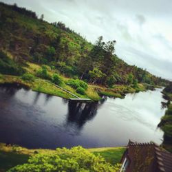 Scenic view of river against cloudy sky