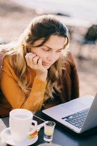 Young woman using laptop at table