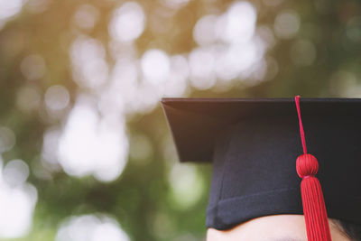 Close-up of man wearing graduation hat