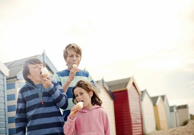 Girl and boys having ice cream at beach