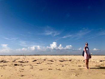 Full length of woman standing on sand against sky