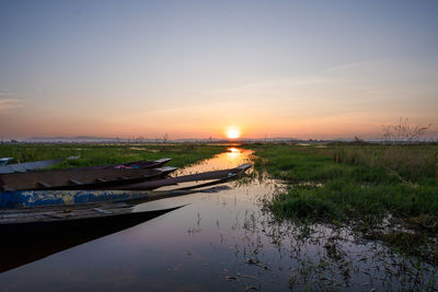 Scenic view of canal against sky during sunset