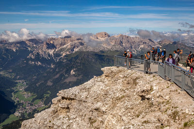 People on rocks against mountains