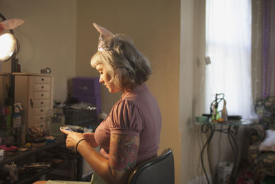 Young woman in front of mirror wearing bunny ears