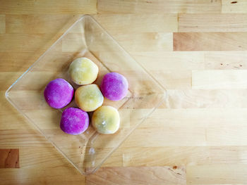 Colourful japanese mochi in a transparent plate on wooden background.