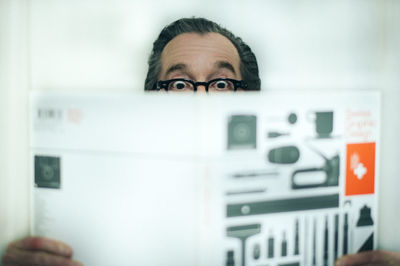 Close-up of mature man reading book at home