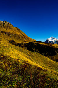 Scenic view of mountains against clear blue sky