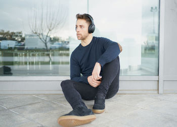 Young man with headphones on city street