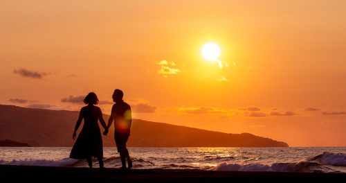 Silhouette couple standing on beach