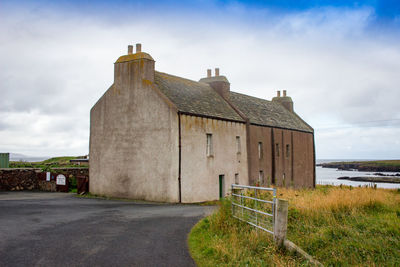 Exterior of historic building on field against sky