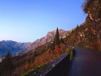 Road amidst mountains against clear sky