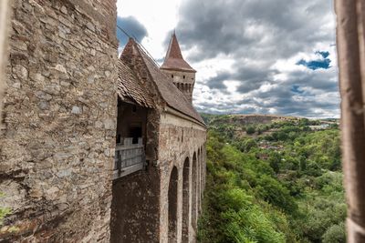 View of bell tower by mountain against sky