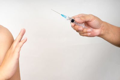 Cropped image of people holding hands over white background