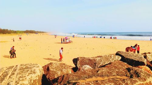 People at beach against sky