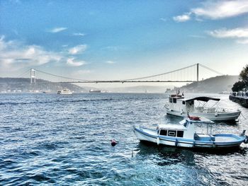 Sailboats moored in sea against sky
