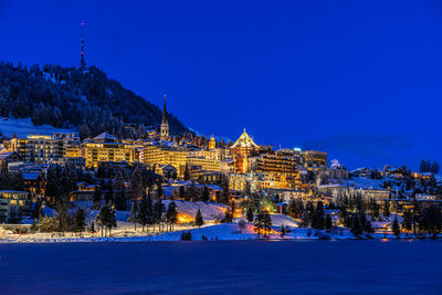 Illuminated buildings against sky during winter