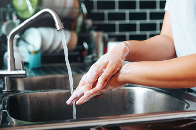 Midsection of woman with hands at home