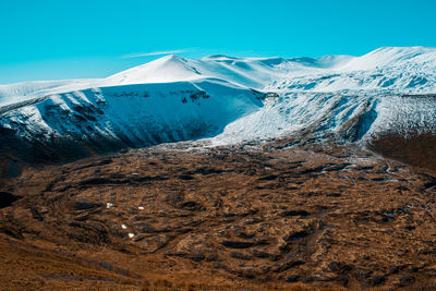 Scenic view of snowcapped mountains against clear blue sky