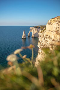 Rock formation in sea against clear sky