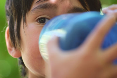 Close-up of boy drinking water from bottle