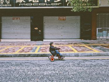 Man riding bicycle on footpath in city