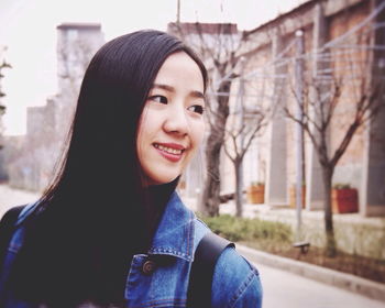 Happy young woman standing on street