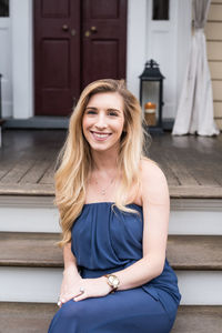 Portrait of smiling young woman sitting on steps