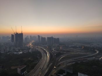 High angle view of street amidst buildings against sky during sunset