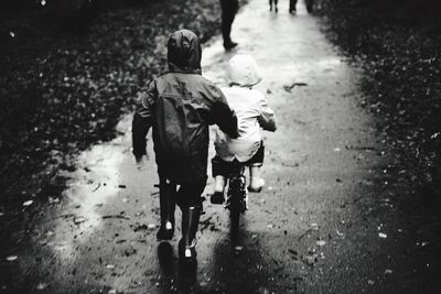 Rear view of people walking on road