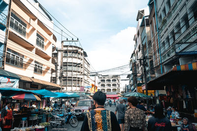 People on street in city against sky