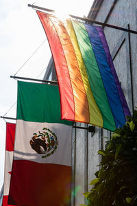 Low angle view of flags hanging against built structure