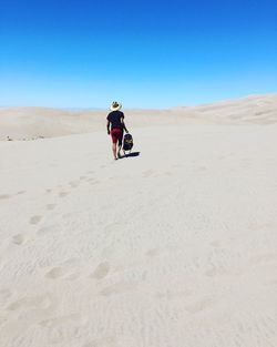 Full length of man on desert against clear sky