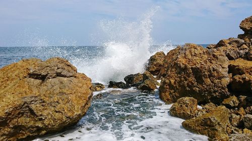 Panoramic view of rocks in sea against sky