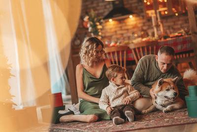 Candid authentic happy family during wintertime together enjoying holidays with dog at xmas