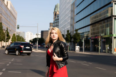 Portrait of woman standing on road in city