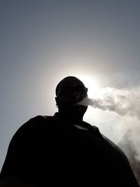 Low angle view of silhouette man standing against clear sky