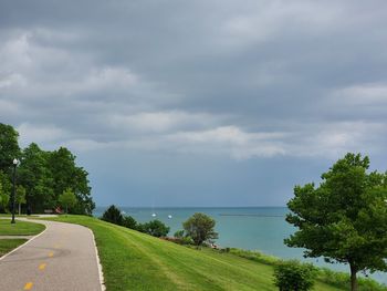 Road by trees against sky