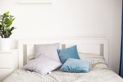 Home comfort, a made-up bed with pillows in a white bright room