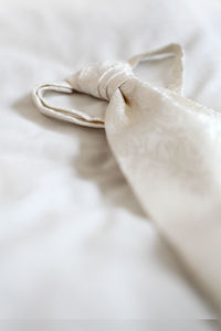 Close-up of wedding rings on bed