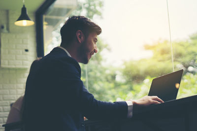 Side view of man using mobile phone