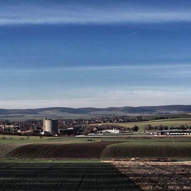 sky, landscape, building exterior, cloud - sky, built structure, architecture, field, cloud, road, mountain, scenics, tranquil scene, rural scene, agriculture, nature, tranquility, beauty in nature, blue, house, cloudy