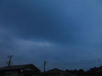 Low angle view of silhouette houses against sky