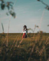 Woman on field against sky