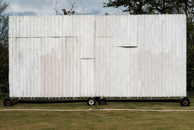 Corrugated iron structure with wheels on field