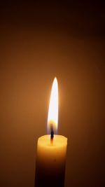 Close-up of lit candle against black background